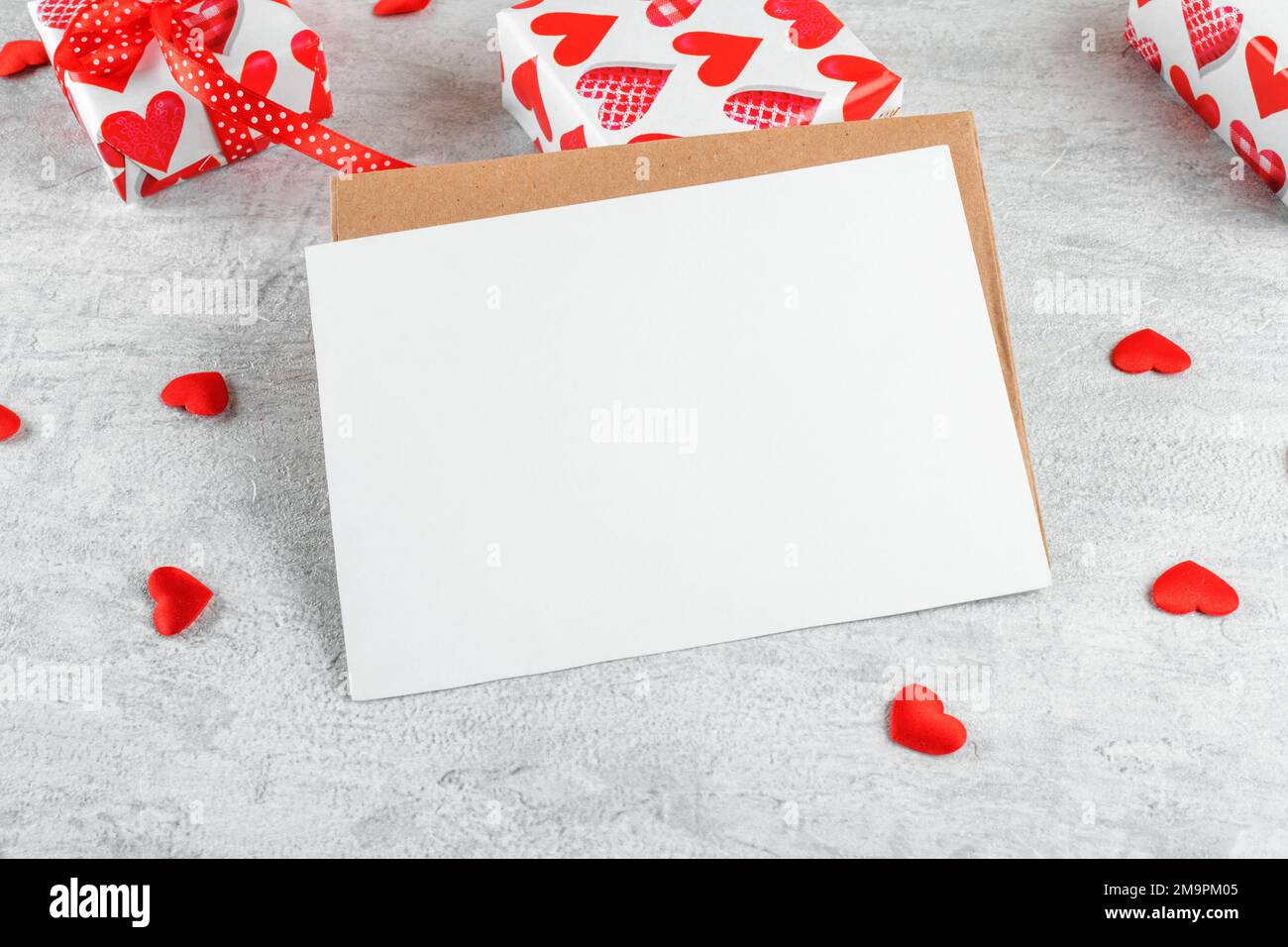 Carte de Saint-Valentin, carte de papeterie d'invitation vierge maquette avec enveloppe et coeurs rouges et cadeaux sur fond clair Banque D'Images
