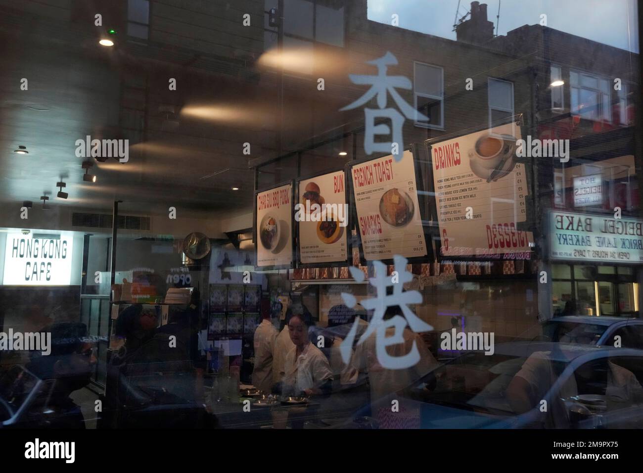 The characters for Hong Kong is seen on the window of the HOKO Cafe, a pop-up cafe in the trendy London neighborhood of Shoreditch that's attracting Londoners and tourists as well as Hong Kong emigres on Nov. 18, 2022. As tens of thousands leave Hong Kong for new lives abroad, many are craving a flavor from childhood that's become a symbol of the city's culture: the sweet, heavy tea with evaporated milk that's served both hot and cold at diner-like restaurants called cha chaan tengs. Workshops are popping up to teach professionals to brew tea like short-order cooks, and milk tea businesses are Banque D'Images
