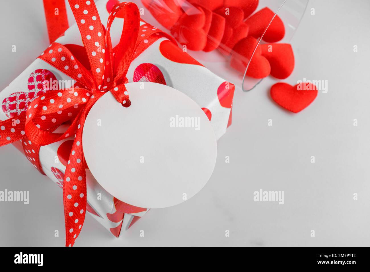 Cadeau de Saint-Valentin avec étiquette cadeau ronde blanche maquette sur fond de marbre avec coeur rouge, solde et concept du Vendredi fou Banque D'Images