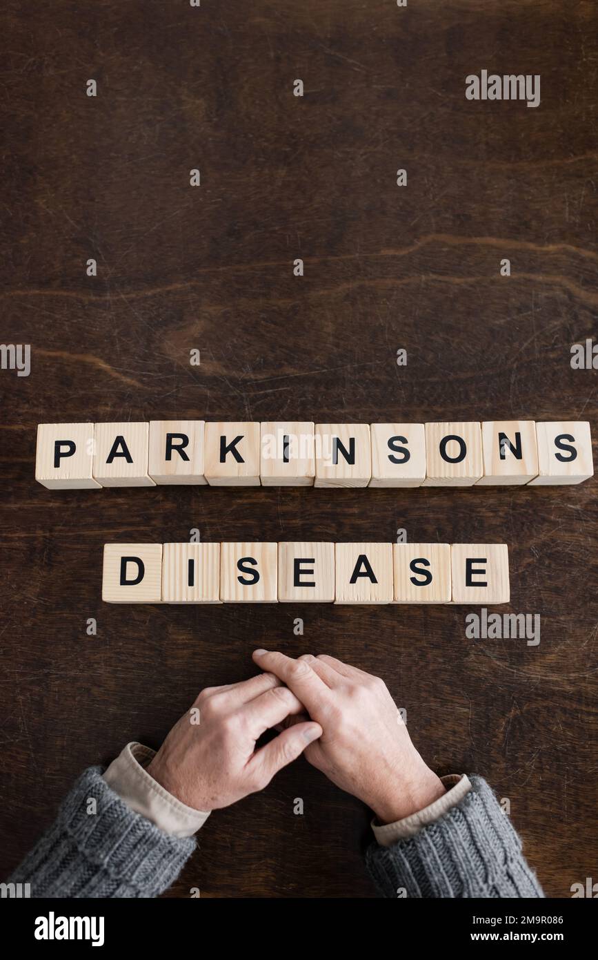 vue de dessus de l'homme âgé cultivé près des blocs avec inscription maladie de parkinsons sur table en bois, image de stock Banque D'Images