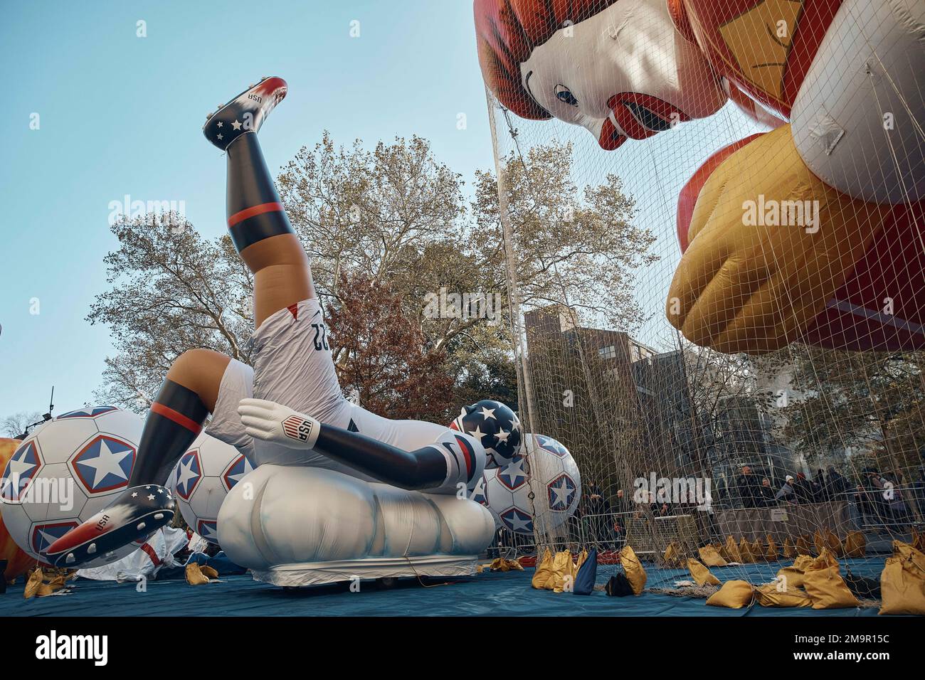People watch at inflated helium balloons of Ronald McDonald and a football player on Wednesday, Nov. 23, 2022, in New York, as the balloon is readied for the Macy's Thanksgiving Day Parade on Thursday. (AP Photo/Andres Kudacki) Banque D'Images