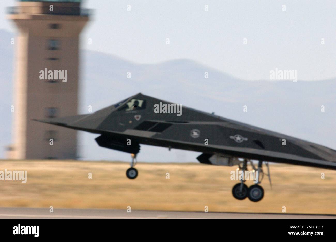 Un F-117A Nighthawk de l'US Air Force (USAF) passe devant la tour de contrôle de la base aérienne de Mountain Home (AFB) pendant le décollage. Le spectacle aérien de trois jours a célébré 100 ans d'aviation et 60 ans de puissance aérienne en Idaho. (Image sous-standard). Base: Mountain Home Air Force base État: Idaho (ID) pays: Etats-Unis d'Amérique (USA) Banque D'Images