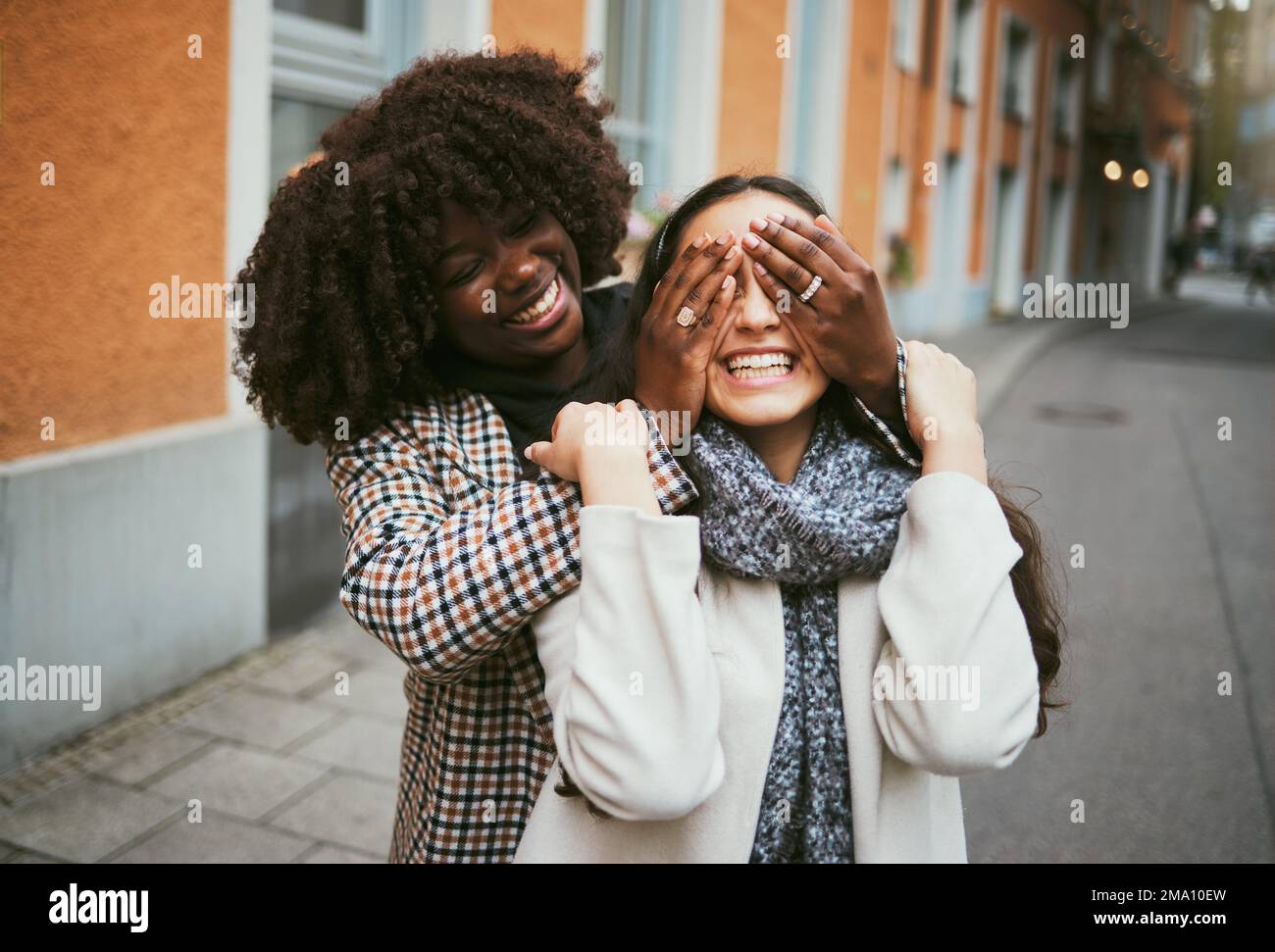 Les femmes, le collage ou les mains couvrant les yeux dans le cache et la recherche, jeu ludique ou comique à New York City, route ou rue. Souriez, heureux ou amis amusants et Banque D'Images