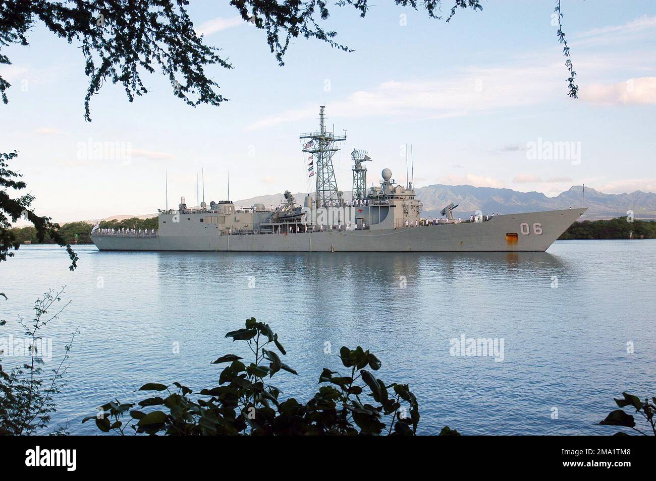 040625-N-8157C-003. [Complete] Scene Caption: The Royal Australian Navy (RAN) Adelaide Class Guided missile Frigate son Majestys Australian Ship (HMAS) NEWCASTLE (FFG 06), avec ses marins 'passant les rails, passe Hospital point à Pearl Harbor, Hawaii, lors de l'arrivée honneurs avant l'exercice maritime multinational RIMPAC (2004). RIMPAC est le plus grand exercice maritime international dans les eaux autour des îles hawaïennes. Cet exercice inclut sept pays participants : l'Australie, le Canada, le Chili, le Japon, la Corée du Sud, Le Royaume-Uni et les États-Unis. Banque D'Images