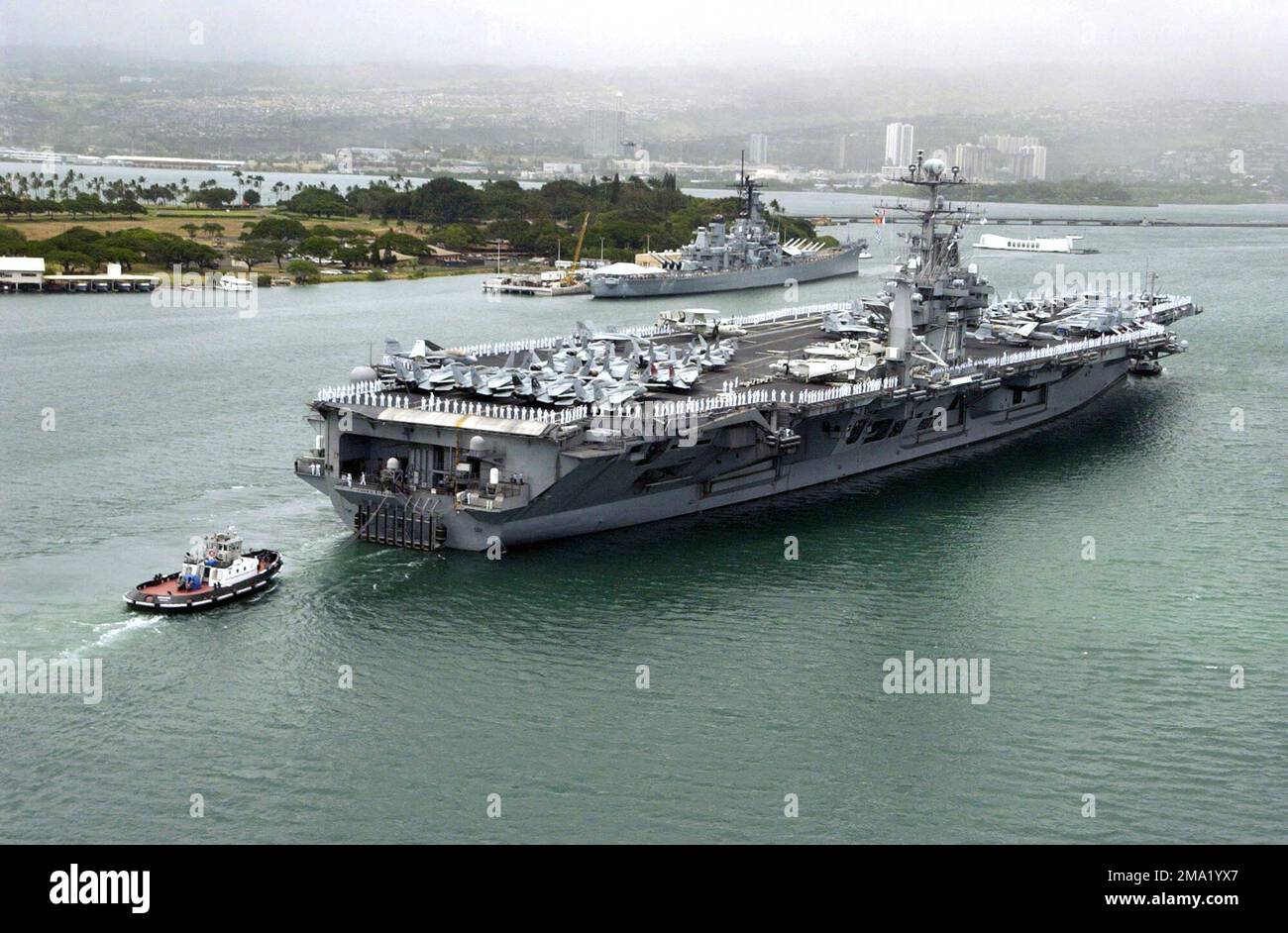040629-N-9312L-021. [Complete] Scene Caption: US Navy (USN) marins man les rails à bord du porte-avions de la classe Nimitz USS JOHN C. STENNIS (CVN 74) alors que le navire se prépare à passer le cuirassé commémoratif USS Missouri (BB 63) et le Mémorial USS Arizona (BB 39) à Pearl Harbor, Hawaii (HI). Ford Island est en arrière-plan. Le STENNIS se rend à Pearl Harbor pour participer à la Rim of the Pacific (RIMPAC) 2004. RIMPAC est le plus grand exercice maritime international dans les eaux autour des îles hawaïennes. Cet exercice comprend sept pays participants : l'Australie, le Canada, le Chili, Jap Banque D'Images