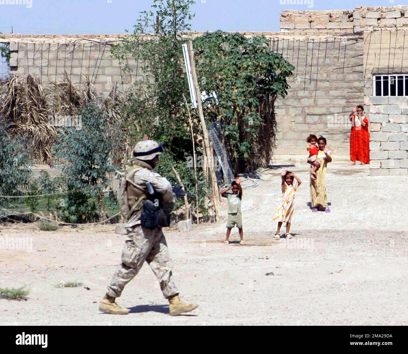 Des enfants iraquiens défercent les troupes du corps des Marines américains (USMC) avec Echo Company, 2nd Bataillon, 1st Marines, 1st Division marine, alors qu'ils patrouillent près de Fallujah, en Irak, pour soutenir l'opération LIBERTÉ IRAQUIENNE. Objet opération/série: LIBERTÉ IRAQUIENNE base: Falloujah État: Al Anbar pays: Irak (IRQ) Banque D'Images