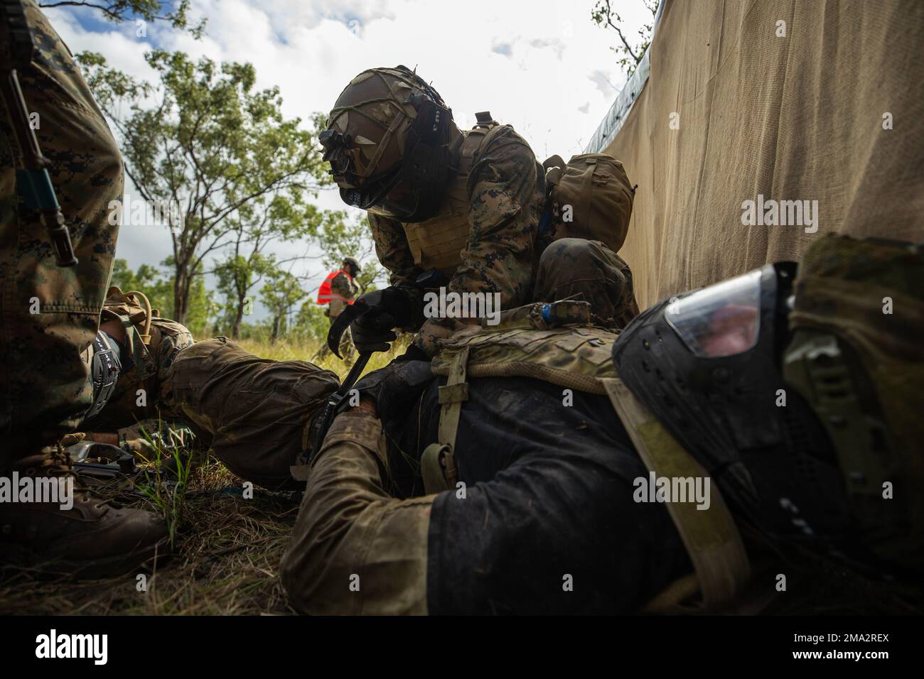 A ÉTATS-UNIS Marine avec Lima Company, 3D Bataillon, 7th Marine Regiment, Ground combat Element, Marine Rotational Force-Darwin 22, applique un tourniquet à une jambe de victimes pendant un entraînement moins que létal dans le cadre de l'exercice Southern Jackaroo 22 à la zone d'entraînement de Shoalwater Bay, Queensland, Australie 24 mai 2022. L'entraînement moins mortel impliquait un scénario de combat utilisant des tours de simunition et est passé à un scénario de victimes massives où les joueurs blessés ont été évalués, traités, puis transportés vers une échelons supérieurs de soins. Banque D'Images