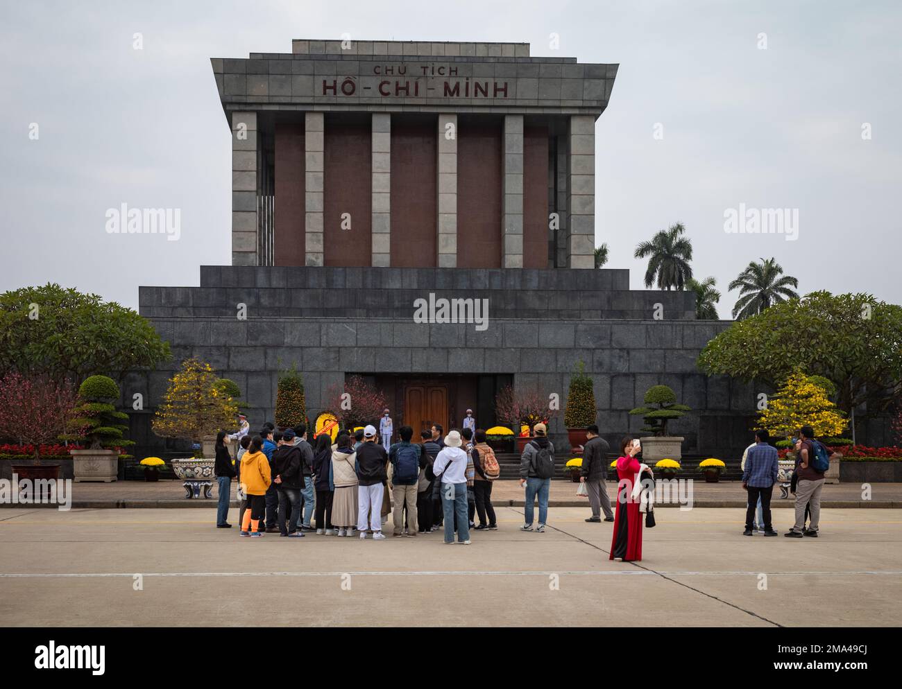 Un groupe de touristes asiatiques se trouve à l'extérieur du mausolée de granit qui abrite le corps embaumé du dirigeant communiste vietnamien vénéré Ho Chi Minh dans le capi Banque D'Images