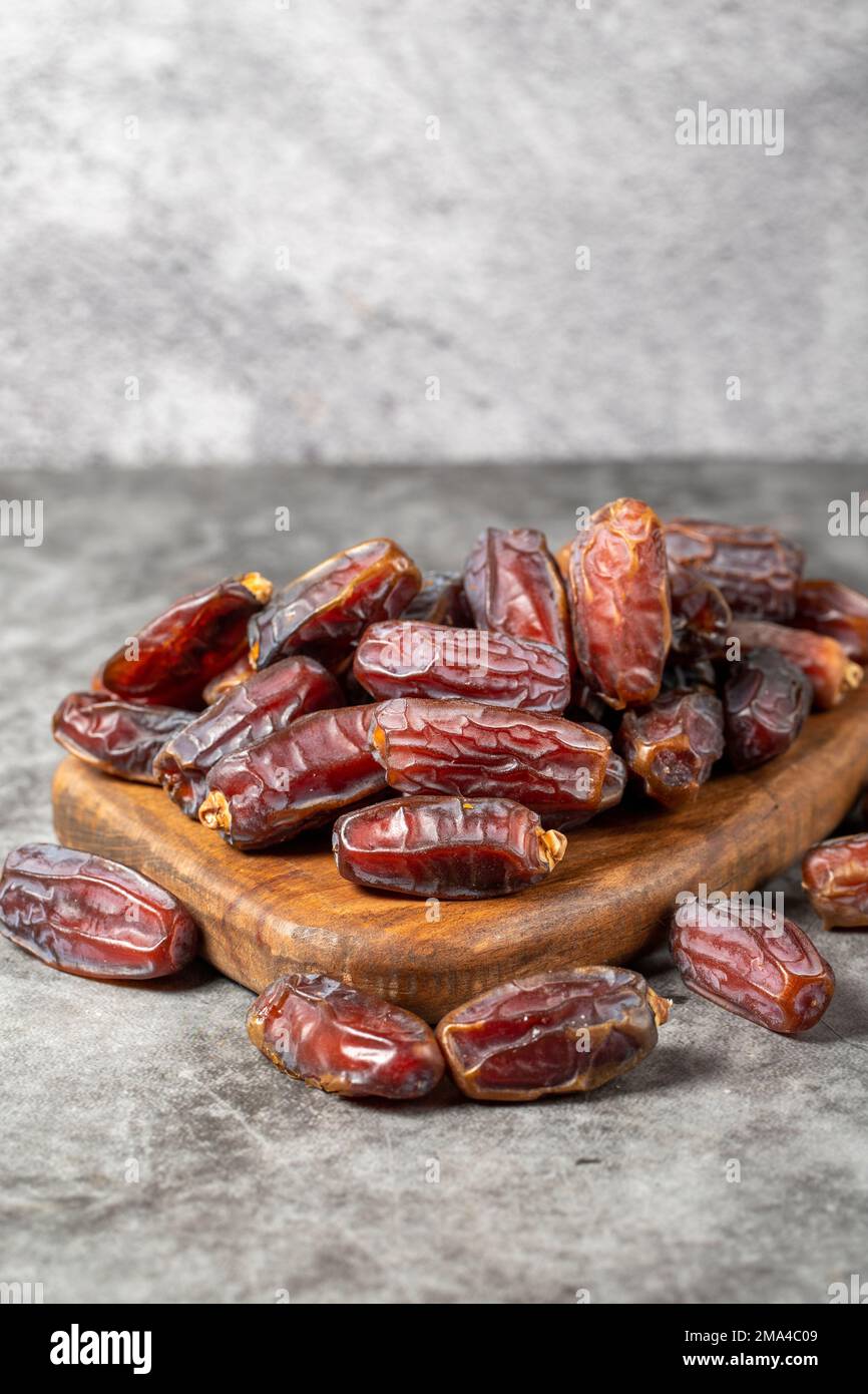 Dater le fruit sur un fond sombre. Pile biologique de dattes médjoules sur une table de service en bois. La nourriture du Ramadan. gros plan Banque D'Images
