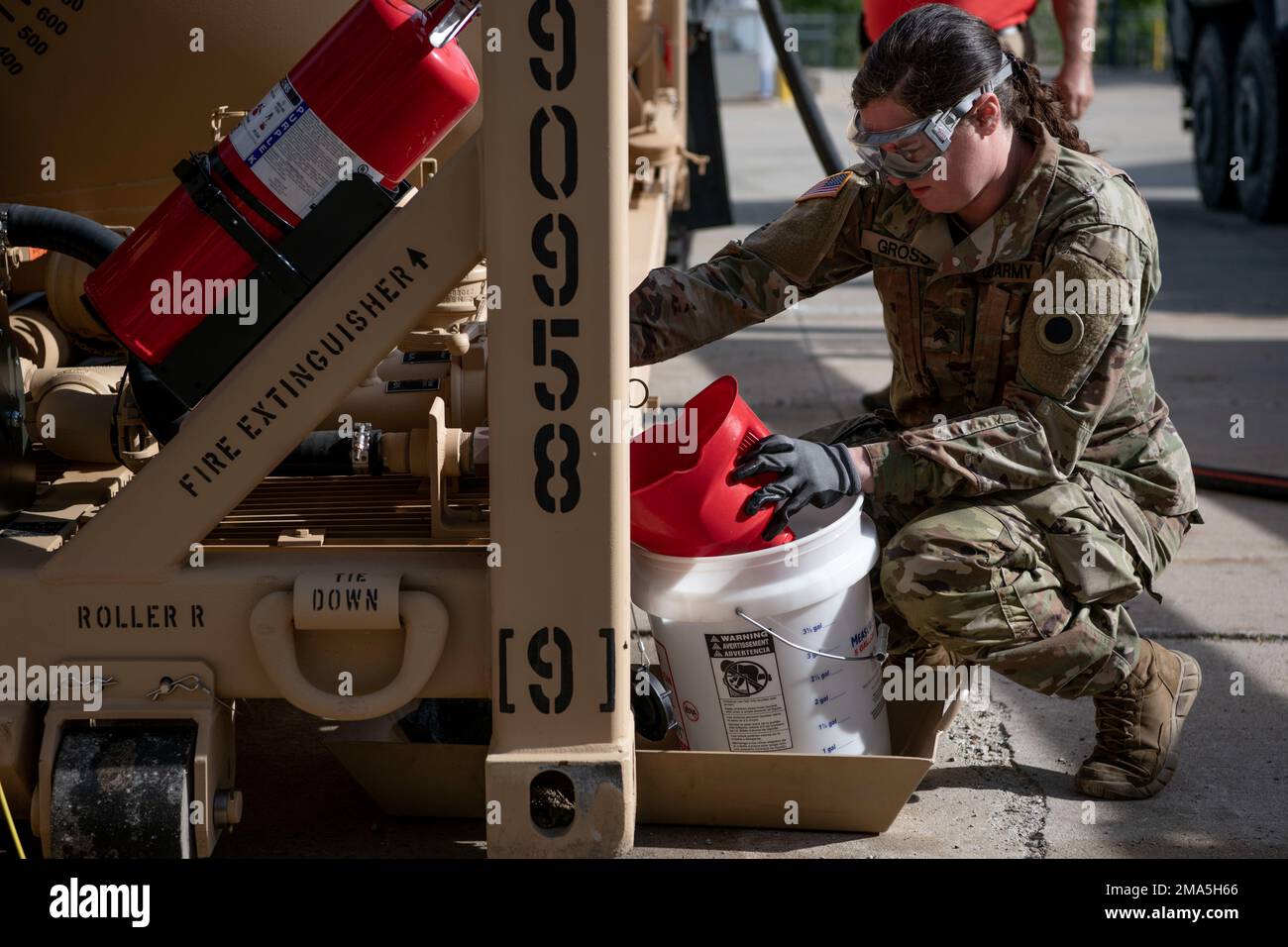 Le Sgt Katherine Gross, membre de la Garde nationale du Michigan, effectue une procédure de rinçage et de recyclage des conduites de carburant sur un module de porte-réservoir au quartier général de la Force interarmées, à Lansing, au Michigan (25 mai 2022). Les équipes de film de TACOM ont documenté le processus, qui sera mis en place dans toute l'Armée de terre pour fournir des conseils pour valider cette réparation. Banque D'Images