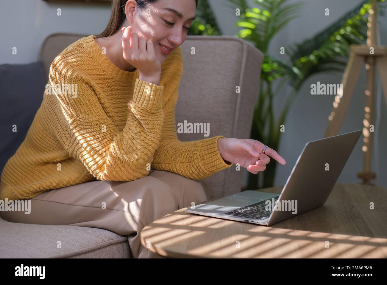 Portrait d'une femme asiatique lisant un livre électronique sur ordinateur portable après se lever le matin. Concept de style de vie matinal Banque D'Images