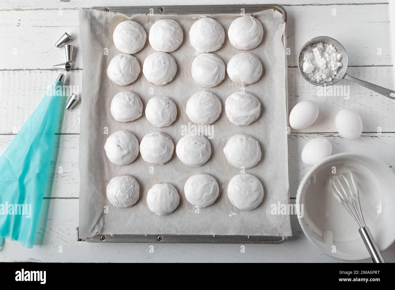 Biscuits au gingembre avec glaçage royal ou glaçage blanc d'œuf sur un plateau de cuisson sur fond blanc d'en haut Banque D'Images