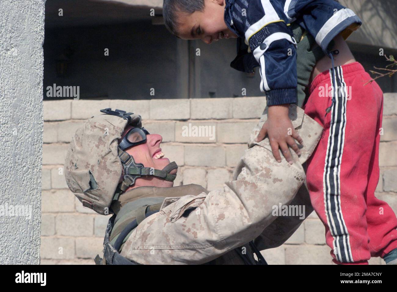 US Marine corps (USMC) Private First Class (PFC) Erskine Blanton, Fox Company (F CO), 2nd Bataillon (BN), 2nd Marine Regiment (MAR REGT), joue avec un enfant iraquien pendant un arrêt de sécurité pendant les opérations à Kharma, en Irak, au cours de l'opération LIBERTÉ IRAQUIENNE. Base: Al Kharma État: Al Anbar pays: Irak (IRQ) Banque D'Images