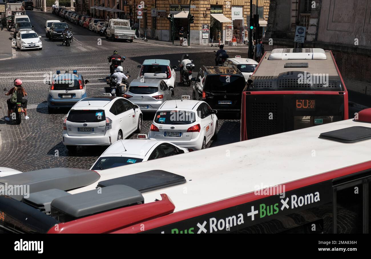 Un carrefour routier très animé à Rome, en Italie, avec bus, voitures et motos qui attendent d'aller au changement de feux. Banque D'Images