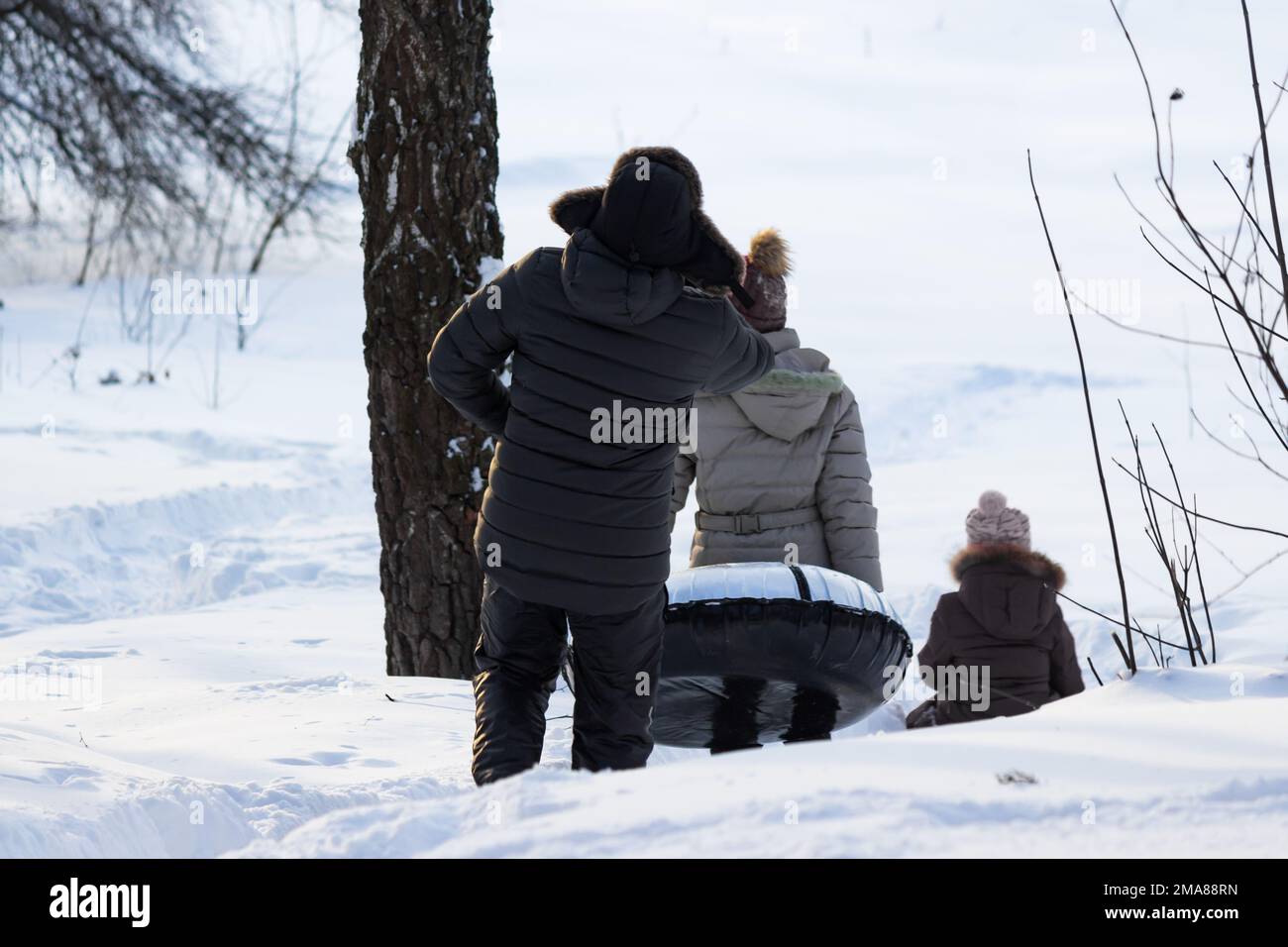 En hiver, faites du ski en famille depuis une glissade sur un toboggan gonflable Banque D'Images