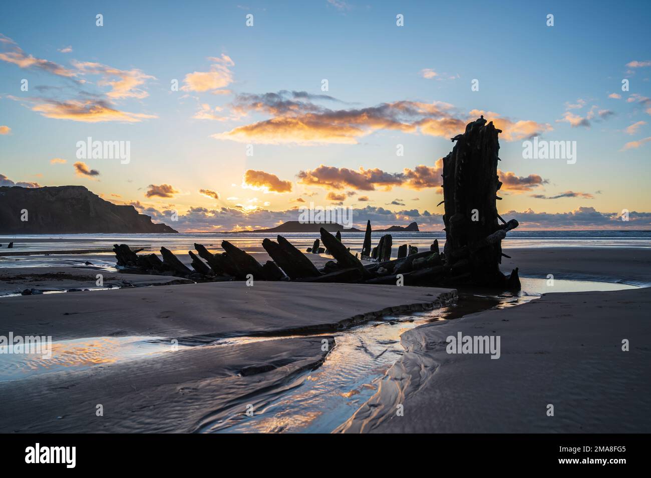 Épave de Helvetia au coucher du soleil, plage de la baie de Rhossili, pas de personnes. Gower Peninsula, pays de Galles du Sud, Royaume-Uni, GB. Banque D'Images