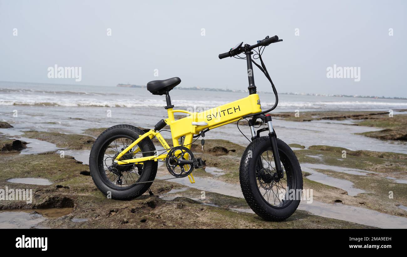 E-bike jaune sur la mer Banque D'Images