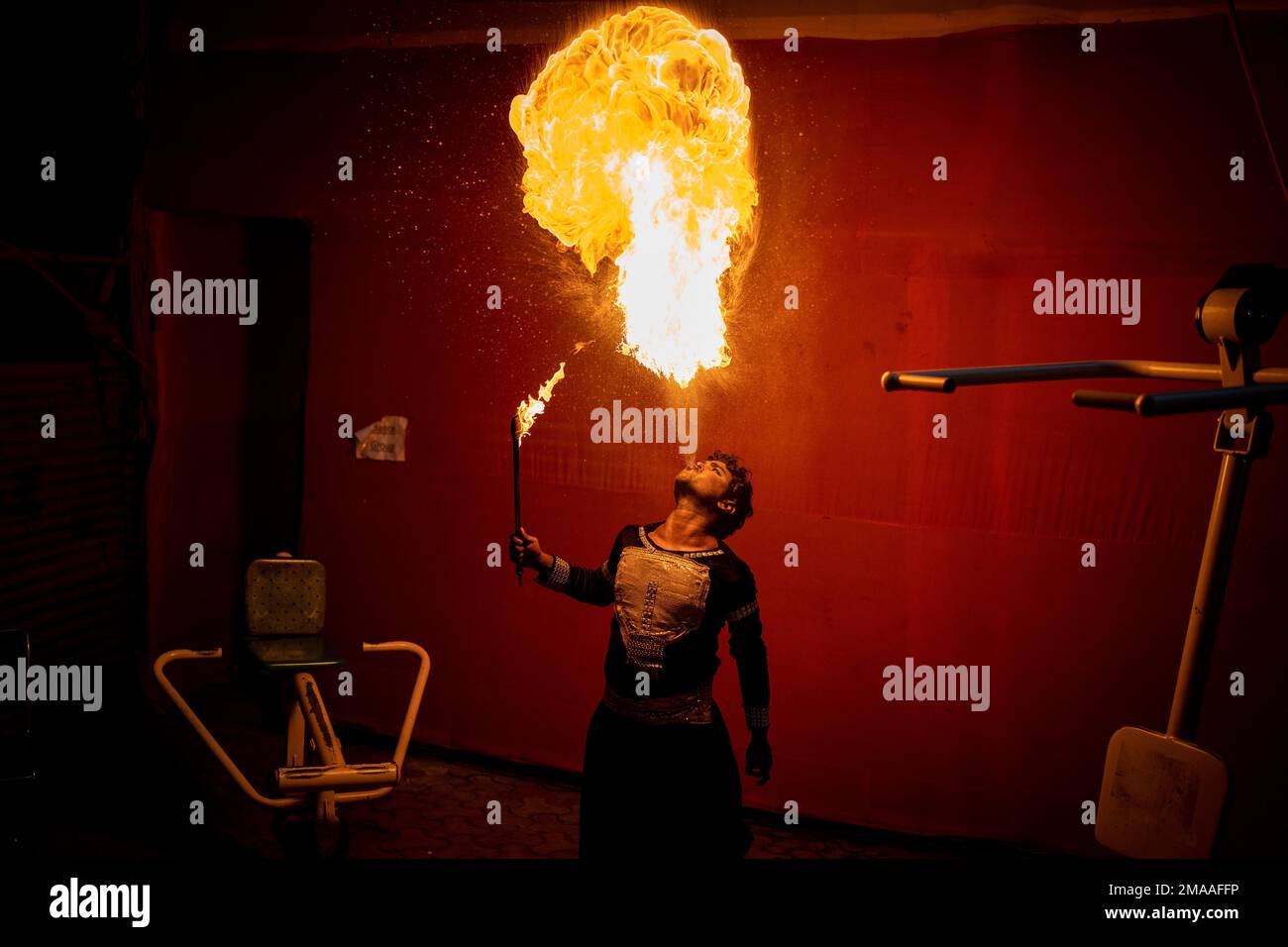 An artist practices fire spitting backstage before the final ...
