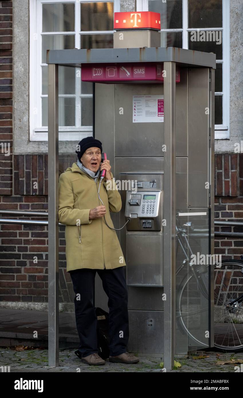 23.11.2022, Allemagne, Brême, Brême - Retraitée femme en rouestige faisant un appel téléphonique à un poste téléphonique Deutsche Telekom. 00A221123D107CAROEX.JPG [MODÈLE Banque D'Images