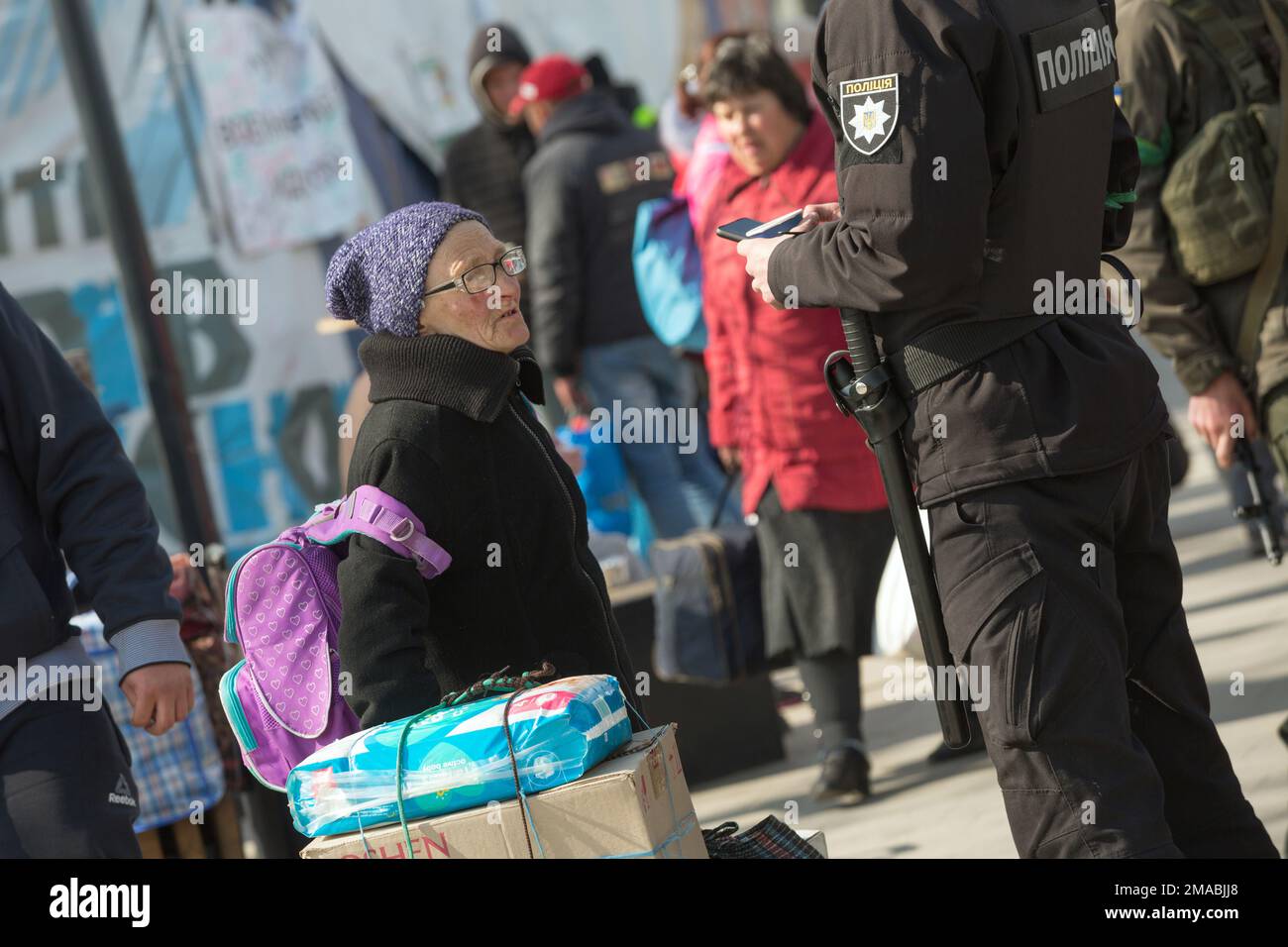 12.04.2022, Ukraine, Oblast, Lviv - les réfugiés de guerre ukrainiens se rassemblent devant la gare principale de Lviv. Une vieille femme avec des bagages parlant à un policier. ATT Banque D'Images 12.04.2022, Ukraine, Oblast, Lviv - les réfugiés de guerre ukrainiens se rassemblent devant la gare principale de Lviv. Une vieille femme avec des bagages parlant à un policier. ATT Banque D'Images