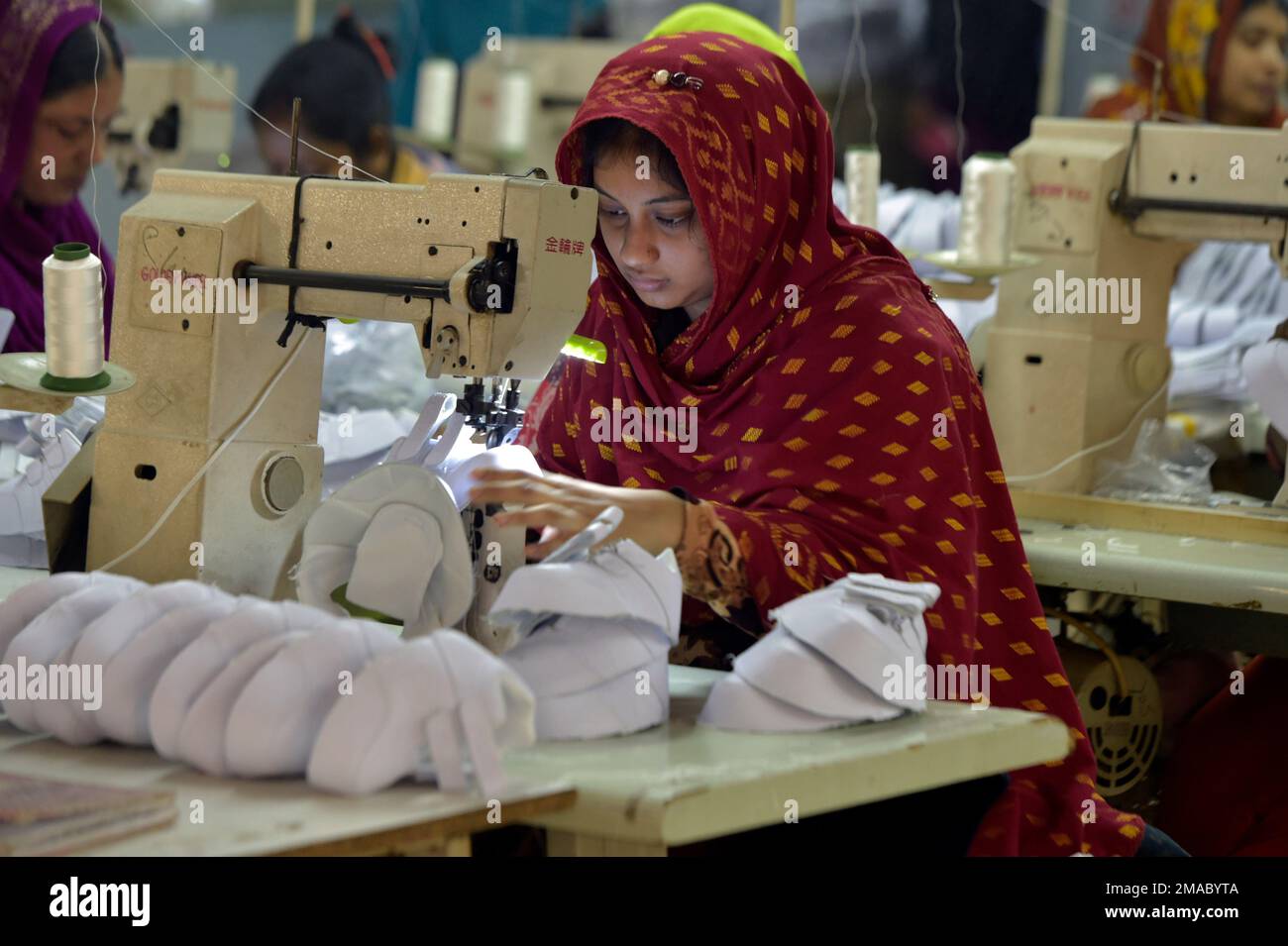 Gazipur. 19th janvier 2023. Le 24 décembre 2022, un travailleur traite des pièces de chaussures à l'usine de fabrication de chaussures investie par les Chinois dans le district de Gazipur, à la périphérie de Dhaka, au Bangladesh. POUR ALLER AVEC 'Feature: Le cordonnier chinois au Bangladesh a réussi à sortir de la marée pandémique' Credit: Xinhua/Alamy Live News Banque D'Images