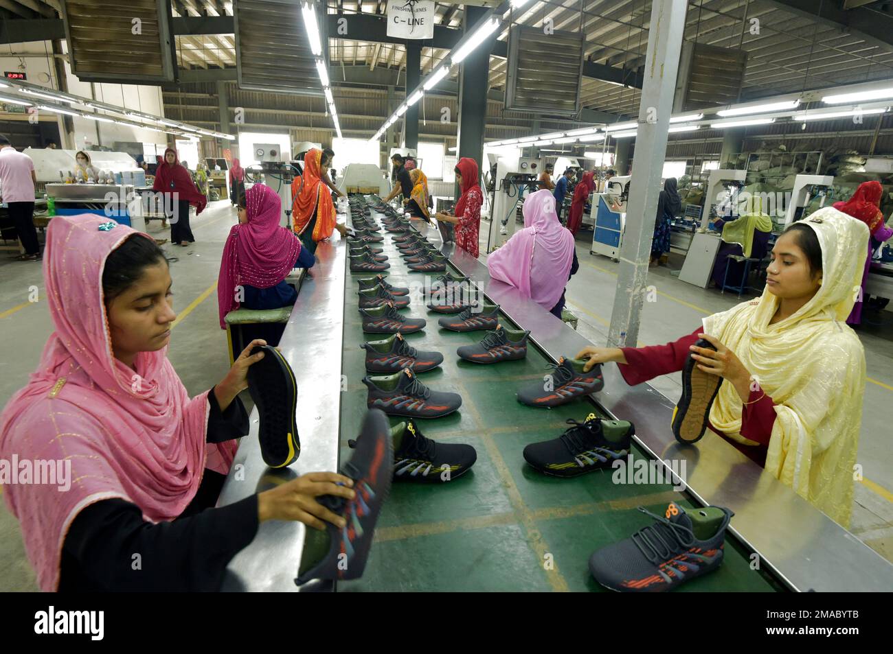 Gazipur. 19th janvier 2023. Le 24 décembre 2022, les travailleurs opèrent sur une ligne de production à l'usine de fabrication de chaussures investie par la Chine dans le district de Gazipur, à la périphérie de Dhaka, au Bangladesh. POUR ALLER AVEC 'Feature: Le cordonnier chinois au Bangladesh a réussi à sortir de la marée pandémique' Credit: Xinhua/Alamy Live News Banque D'Images