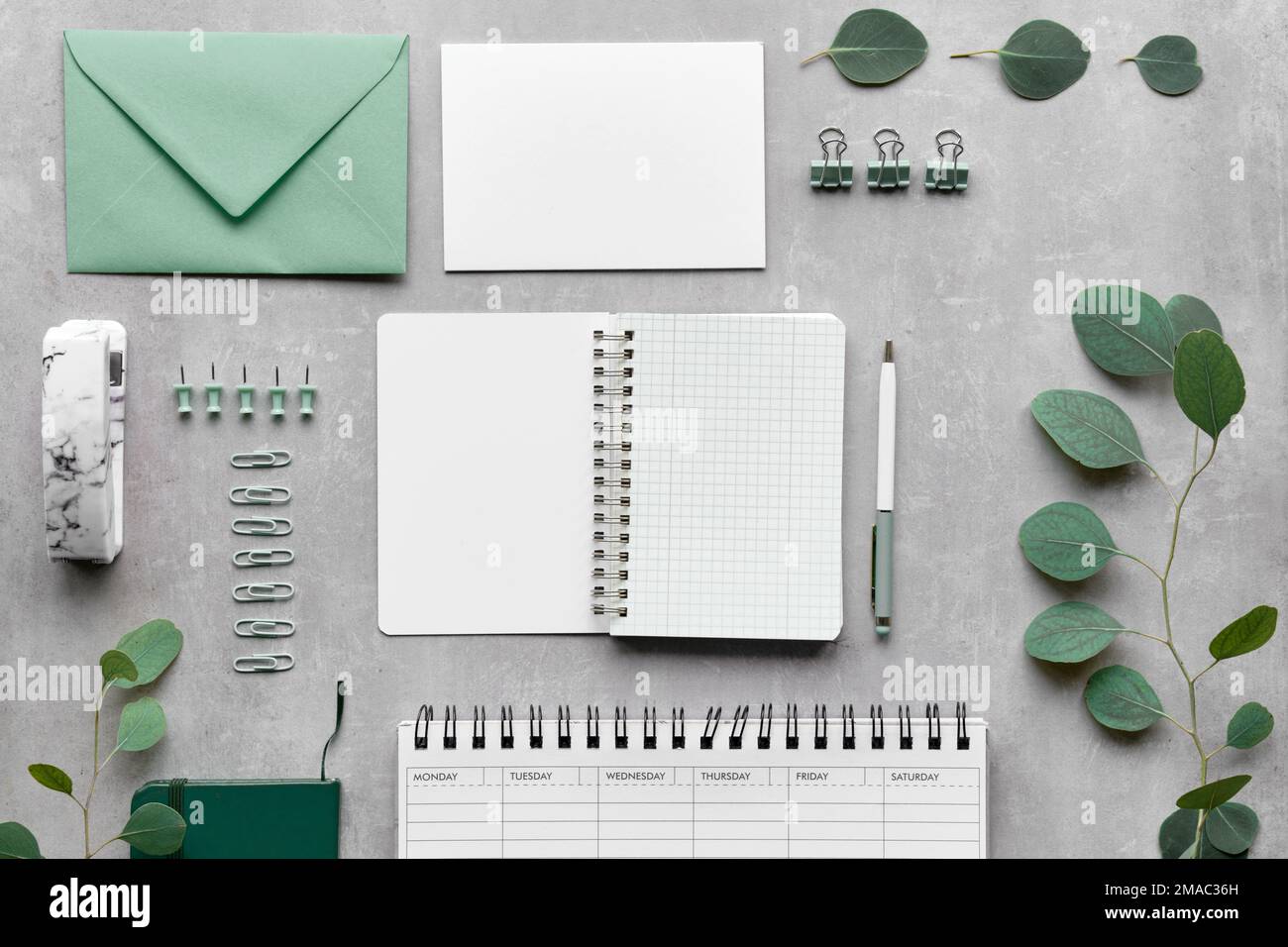 Knolling bureau à domicile fixe. Vue de dessus de la table d'examen. Enveloppe, carte postale, épingles, chevilles, stylo, planning hebdomadaire, calendrier soigneusement organisé. Vue de dessus Banque D'Images