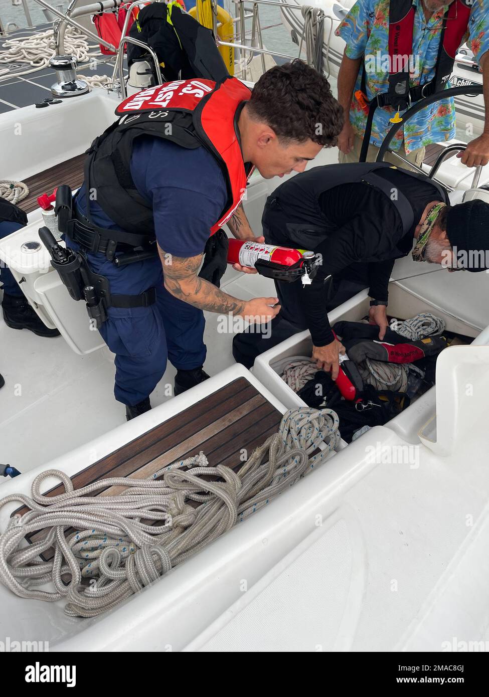 Garde côtière Petty Officer 2nd classe David Reynolds, un compagnon de bateau à la station Galveston, inspecte un extincteur à bord d’un voilier de 50 pieds handicapé près de Galveston, Texas, 25 mai 2022. Après avoir aidé les deux plaisanciers à remorquer leur navire à terre, l'équipage de la Station Galveston a inspecté leur équipement de sécurité pour s'assurer que le navire était conforme à toutes les lois et tous les règlements. Banque D'Images