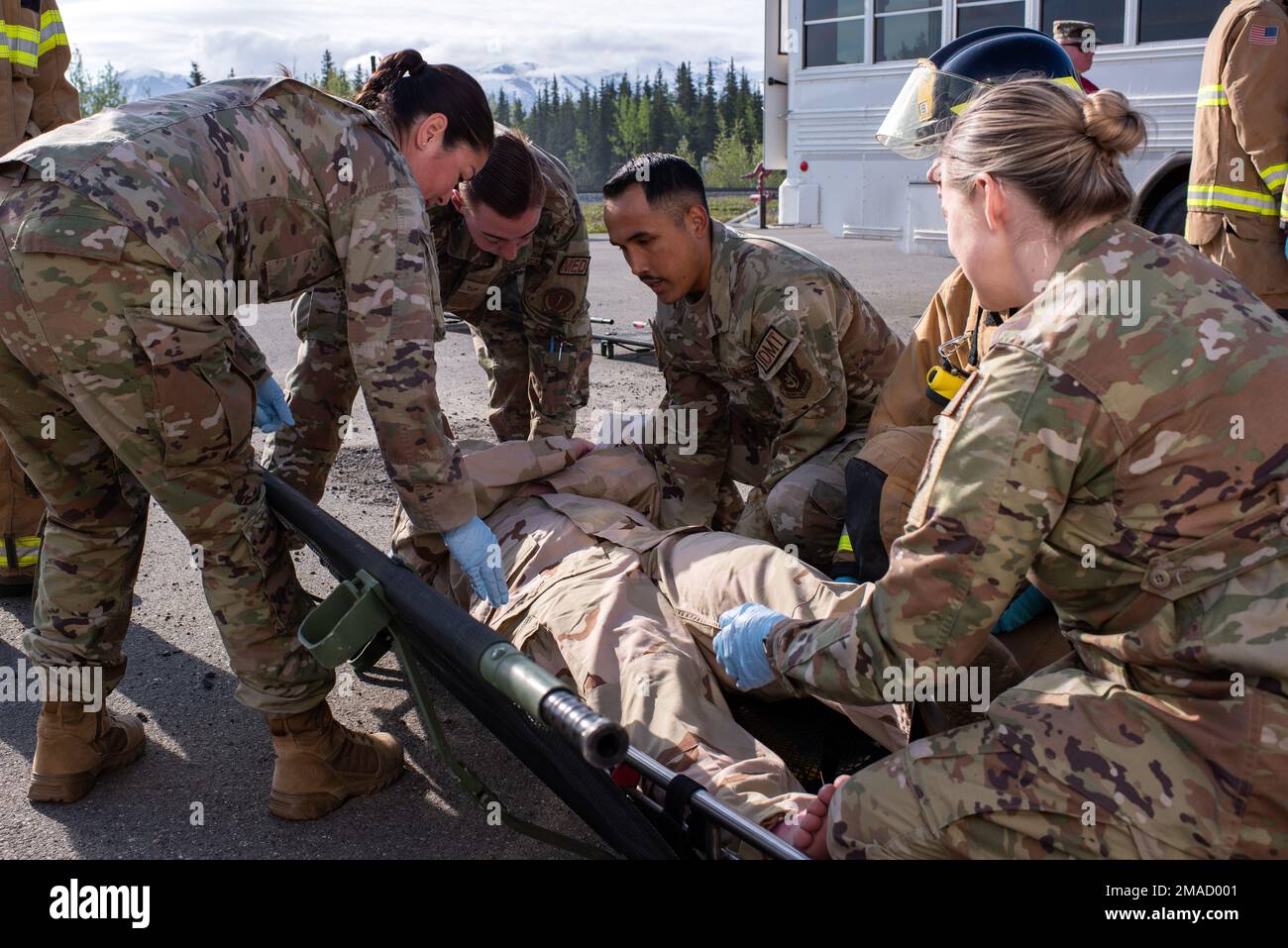 Le personnel médical de la Force aérienne affecté au groupe médical 673d déplace une victime simulée vers une litière d'évacuation tout en participant à l'exercice d'assurance de mission 22-6 à la base conjointe Elmendorf-Richardson, Alaska, 25 mai 2022. MAE 22-6 a testé les capacités d'intervention d'urgence de JBER à la suite d'un accident de maquette d'avion. Banque D'Images