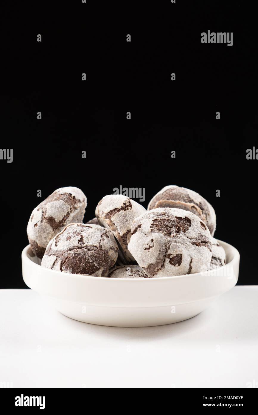 Biscuits aux pépites de chocolat avec cacao et sucre en poudre sur une  assiette sur fond noir Photo Stock - Alamy