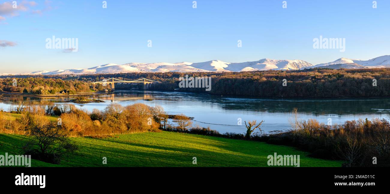 Le pont de menai avec des montagnes enneigées derrière. Banque D'Images