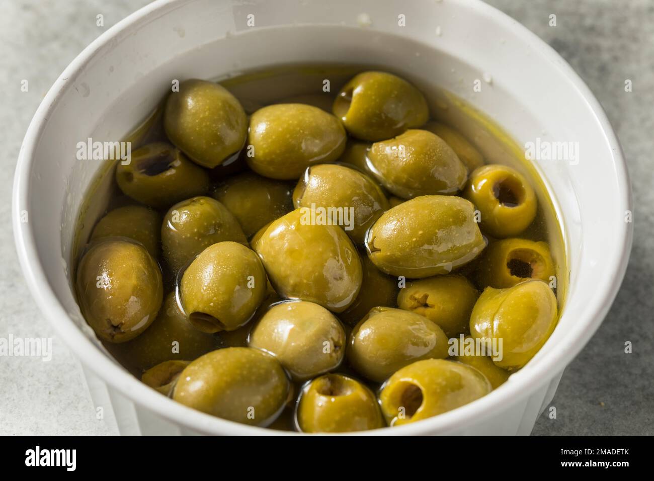 Olives vertes brutes marinées dans l'huile Banque D'Images