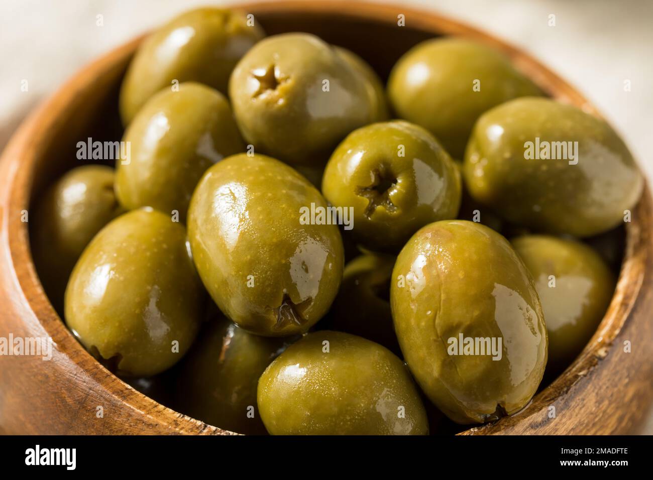 Olives vertes brutes marinées dans l'huile Banque D'Images