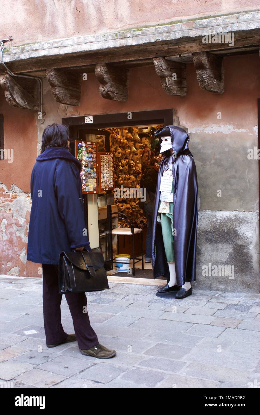 Un homme regarde un costume de carnaval médiéval dans un magasin de Venise. Italie Banque D'Images