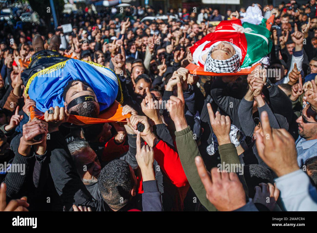 Jenin, Moyen-Orient. 19th janvier 2023. (NOTE DE LA RÉDACTION: L'image dépeint la mort)les boureurs et les hommes armés portent les corps des Palestiniens, Adham Jabareen, 28 ans, à gauche, et l'enseignant d'école Jawad Bawaqna, 57 ans, à droite, Qui ont été tués par des balles de l'armée israélienne lors d'un raid dans le camp de réfugiés de Jénine, lors de leur cérémonie funéraire dans la ville de Jénine, en Cisjordanie occupée. Des témoins oculaires ont déclaré que Jabareen avait été tué par balle par l'armée israélienne lors d'affrontements avec des armes à feu, et l'enseignant de l'école Bawaqnah a essayé de lui fournir les premiers soins après qu'il soit tombé au sol. Au cours de sa tentative de l'aider, un ISR Banque D'Images