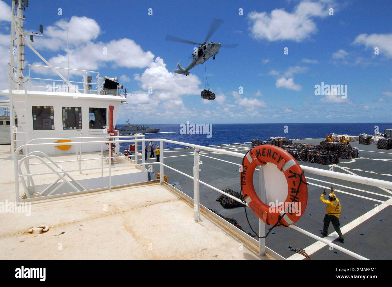 060514-N-6501M-004. [Complete] Scene Caption: US Navy (USN) Aviation Boatswain's Mate second Class (AB2) Brandon Reyes signale au pilote d'un hélicoptère USN MH-60s Sea Hawk, affecté à l'escadron de combat en mer 25 (HSC-25), comme il livre des fournitures au pont de vol à bord du Commandement militaire de Sealift (MSC) de l'USN, à bord du navire de l'hôpital, USNS MERCY (T-AH 19), lors d'une évolution de reconstitution en mer (RAS) avec la classe Mars MSC USN: Navire de combat, USNS Concord (T- AFS 5). La MISÉRICORDE de l'USNS est actuellement en cours dans l'océan Pacifique, menant un déploiement de cinq mois prévu pour fournir l'aide A. Banque D'Images