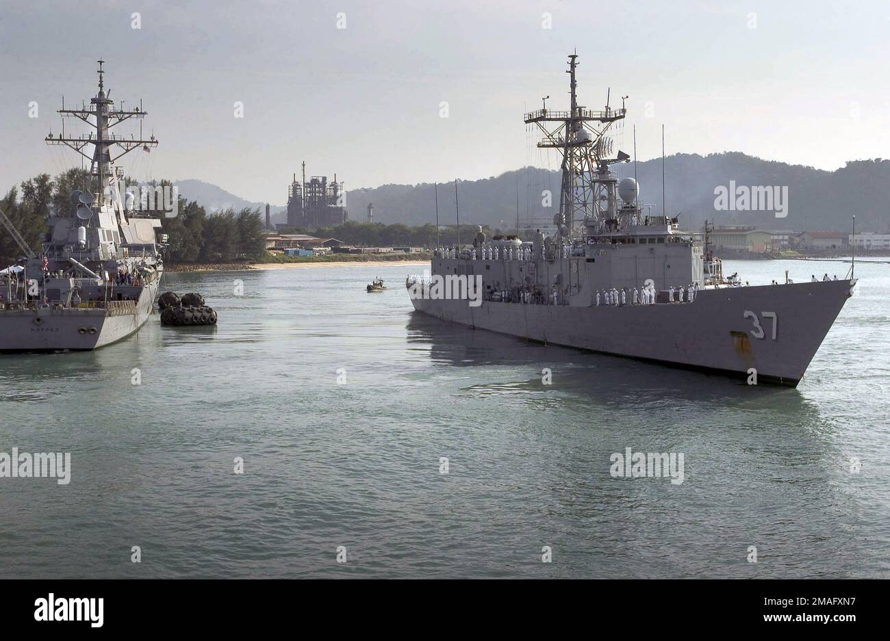 060803-N-9851B-001. [Complete] Scene Caption: 060803-N-9851B-001 (le 3 août 2006)Une vue de l'arc à tribord de la marine américaine (USN) Oliver Perry Hazard Class Guided missile Frégate USS CROMMELIN (FFG 37) montrant les marins à bord des rails tandis que le navire passe devant la USN Arleigh Burke Class (vol II) Guided missile Destroyer (AEGIS HOPPER) (DDG 70), en sortant du port de Kemaman, en Malaisie. Les navires de guerre de l'USN sont en train de mettre fin à la quatrième phase de l'exercice de coopération, de préparation et de formation (CARAT). CARAT est une série annuelle d'exercices bilatéraux de formation maritime entre les États-Unis et six Sud-est Banque D'Images