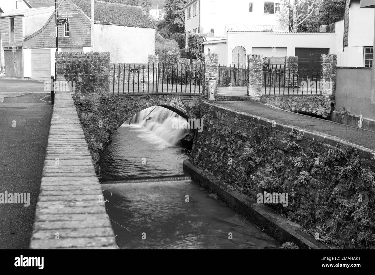 Longue exposition d'un écoulement d'eau sous un pont sur la rivière Lim Walkway à Lyme Regis dans Dorset. Banque D'Images