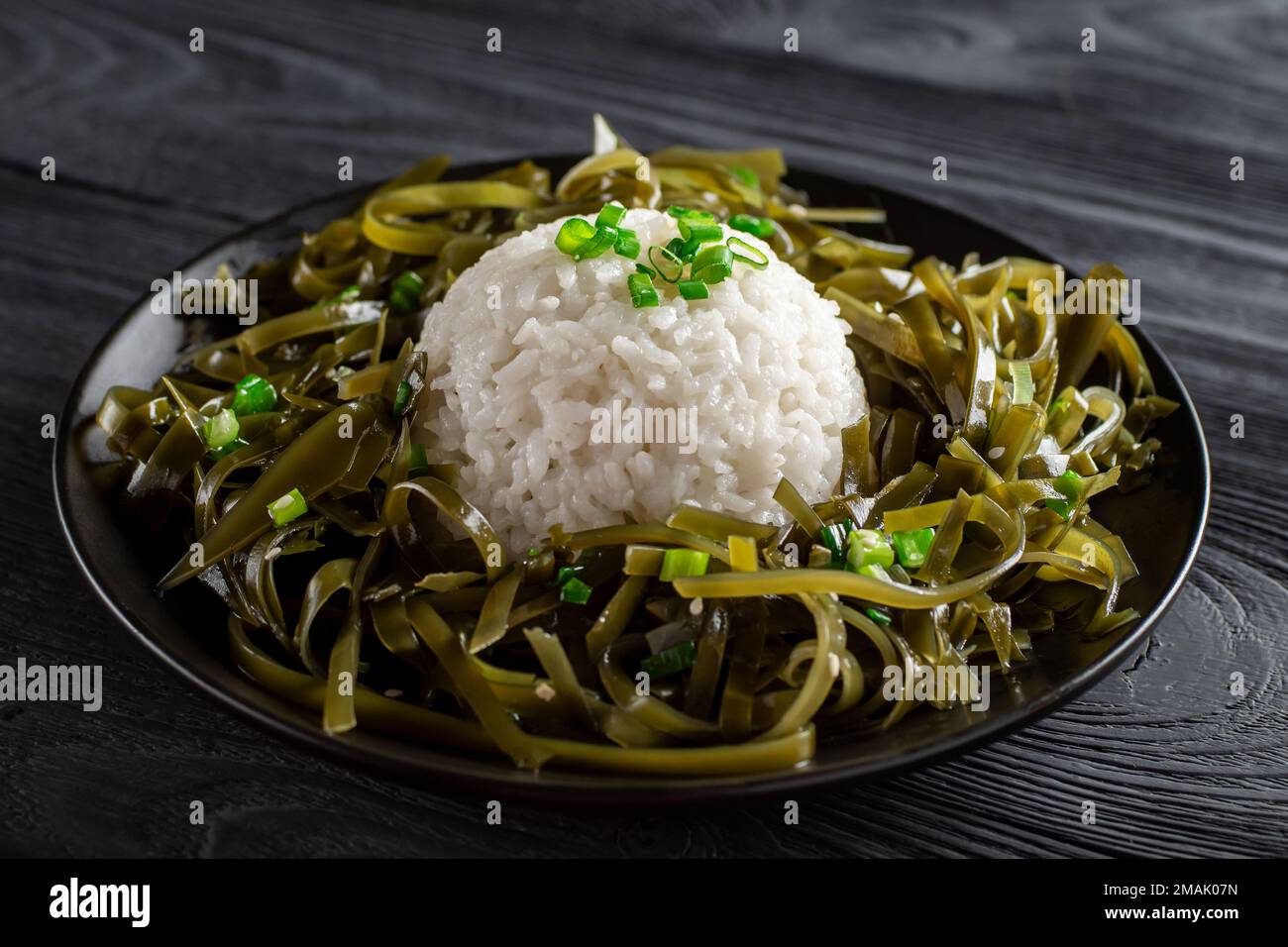 Cuisine coréenne. Manger sainement. Apéritif d'algues de Kelp (laminaria)  avec du riz cuit sur une assiette noire. Concept de nourriture saine.  Tradition. Cu Photo Stock - Alamy