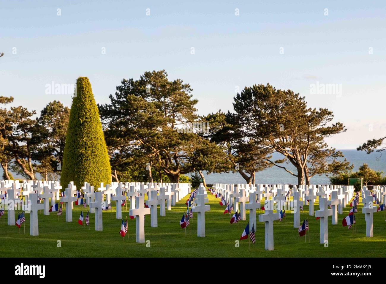 Les drapeaux français et américains se branle dans le vent à côté des pierres à tête du cimetière américain de Normandie à Coleville, en France, au 29 mai 2022. Une cérémonie a eu lieu pour honorer les troupes américaines tombées dans l'opération Overlord ou le jour J. Sur 6 juin 1944, plus de 150 000 soldats des forces alliées ont pris d'assaut la plage de Normandie dans ce que l'on appelle la plus grande invasion maritime de l'histoire. Environ 4 000 soldats ont perdu la vie et la bataille a changé le cours de la Seconde Guerre mondiale. (É.-U. Photographie de l'armée par le sergent d'état-major Alexander Skripnichuk) Banque D'Images