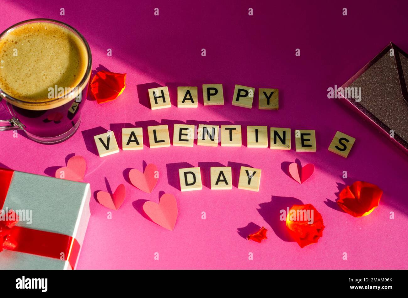 La Saint-Valentin. Rose rouge dans un vase en verre sur fond rose. Banque D'Images
