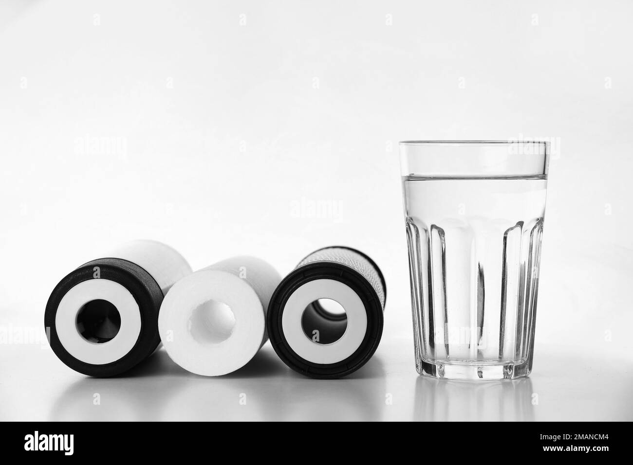 Bannière de trois cartouches pour filtre à eau avec verre d'eau propre isolé sur fond blanc. Installation de RO, eau d'osmose inverse Banque D'Images