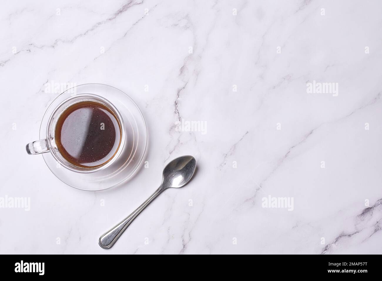 une tasse de café et une cuillère sur une surface en marbre blanc avec un espace de copie dans le coin supérieur droit Banque D'Images