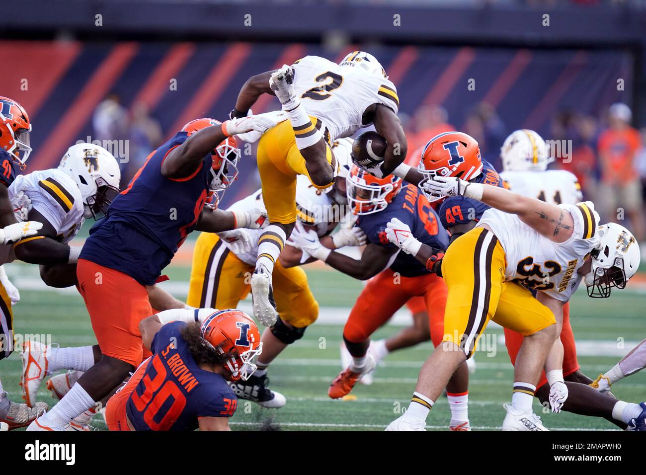 Wyoming running back Titus Swen (2) leaps over Illinois defensive back Sydney Brown during the second half of an NCAA college football game Saturday, Aug. 27, 2022, in Champaign, Ill. (AP Photo/Charles Rex Arbogast) Banque D'Images