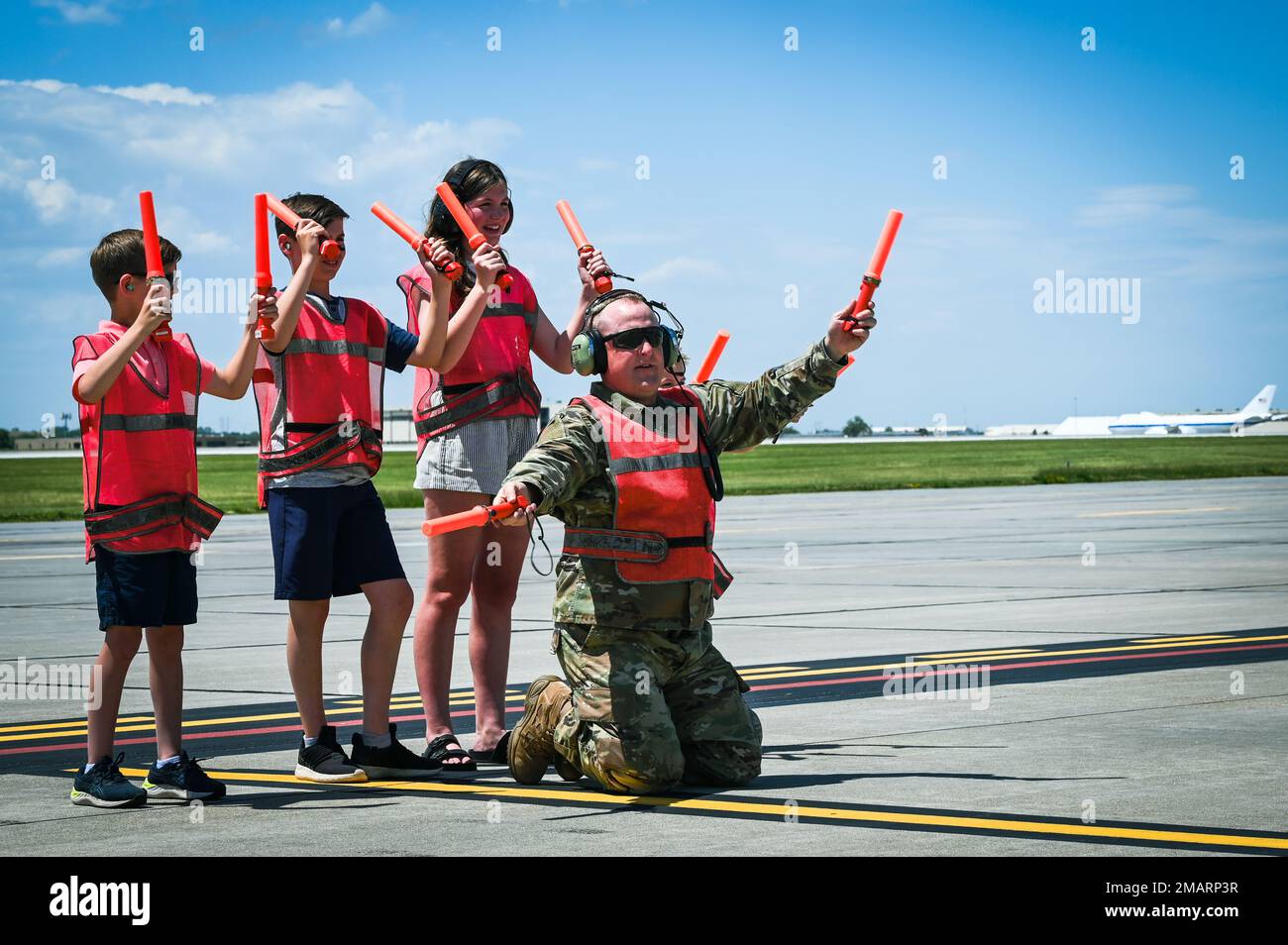 Le Sgt. Chef-maître Chad Martin, surintendant de l’Escadron de maintenance des aéronefs 155th, aide sa nièce et ses neveux à signaler de stationner le jet, 4 juin 2022, pendant le vol fini du Maj. Troy Martin à la base aérienne de Lincoln, ONÉ. Martin a eu 3 800 heures de vol pendant sa carrière militaire. Banque D'Images