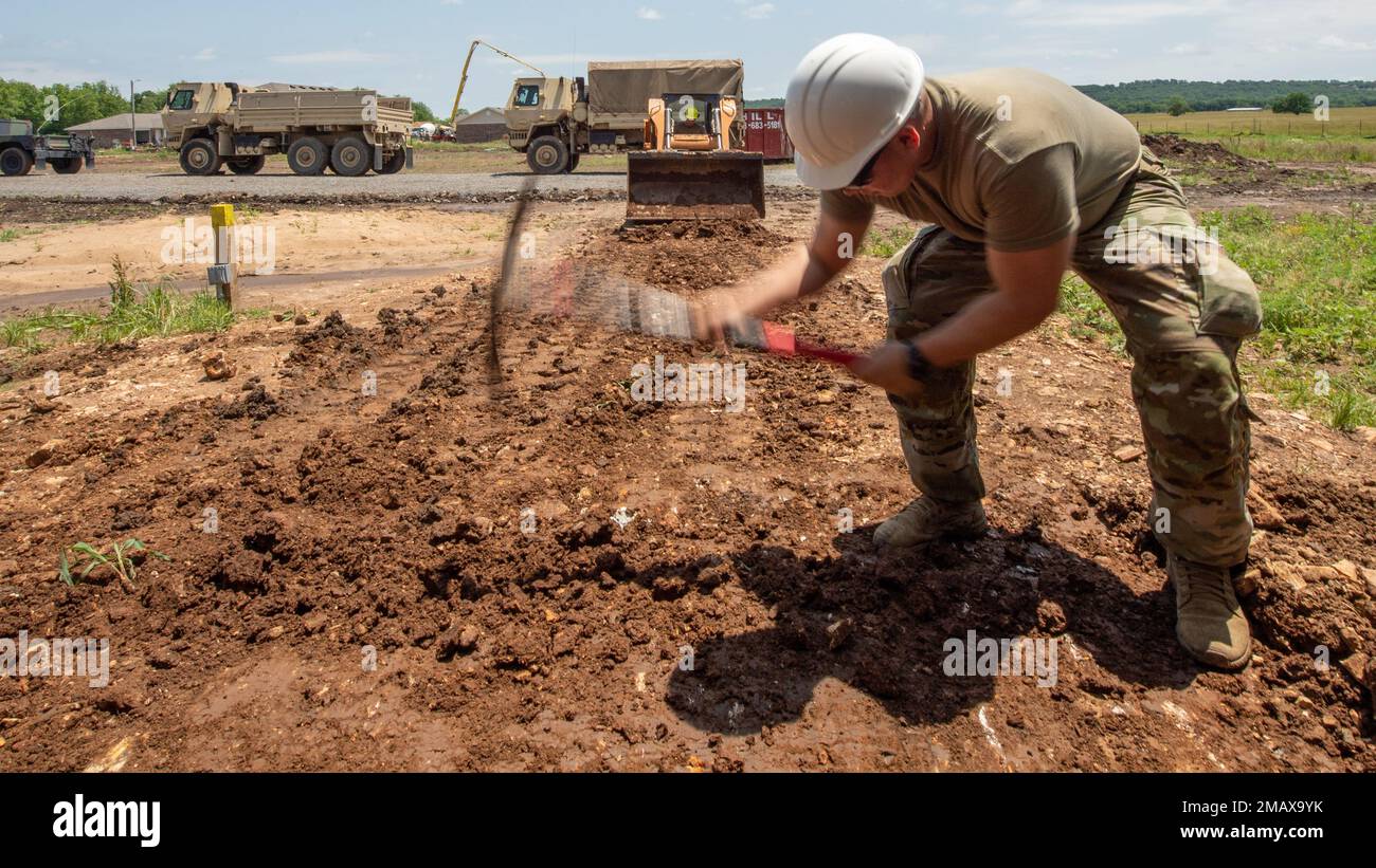 Mason Cruz, un électricien d'intérieur avec la compagnie d'ingénierie 2120th Broken Arrow, Oklahoma, décompose la terre avec un pioche lors d'une mission de formation de préparation innovante pour la nation Cherokee à Tahlequah, Oklahoma, 6 juin 2022. Cette mission de l'IRT était unique en ce que les Soliders, les aviateurs et les fonctionnaires, la garde, la réserve, et le devoir actif a travaillé main dans la main pour accomplir le projet novateur de logement. Banque D'Images