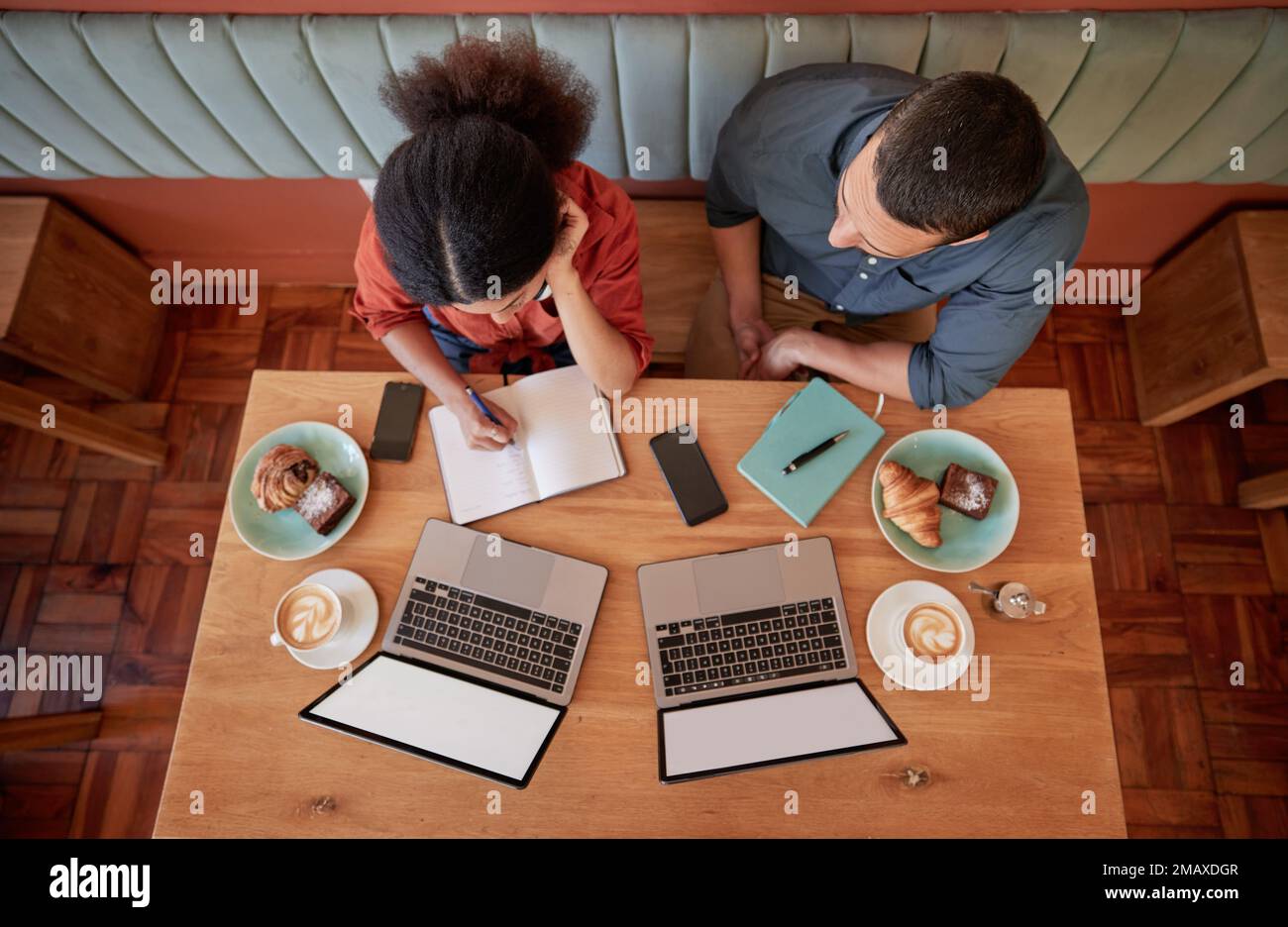 Travail, café-restaurant et ordinateurs portables avec maquette et groupe de travail planifiant une stratégie. Table, au-dessus et café travail d'un web design personnel Banque D'Images
