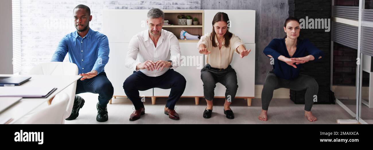 Groupe d'Happy Young Businesspeople Doing Stretching Exercice in Office Banque D'Images