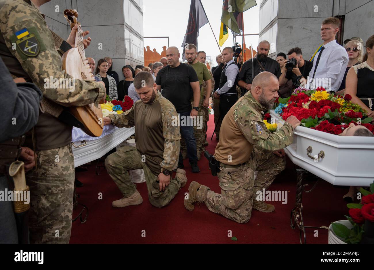 Fellow soldiers stand kneeling as they attend the funeral of officers Andriy Zhovanyk and Yuri Kovalenko, who were killed in a battle against the Russian troops, in central Independence square in Kyiv, Ukraine, Friday, Aug. 5, 2022. (AP Photo/Efrem Lukatsky) Banque D'Images