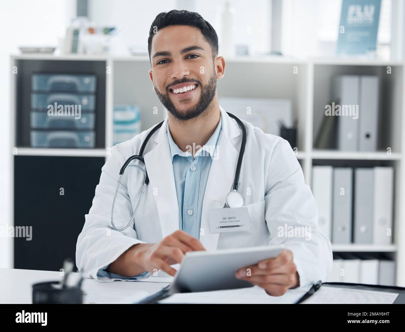 Votre sympathique généraliste de quartier. un jeune médecin utilisant une tablette numérique dans un bureau. Banque D'Images